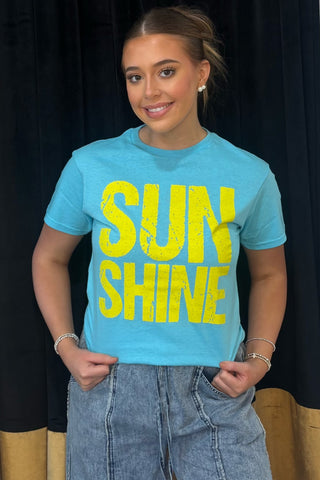 Person wearing a blue t-shirt with 'SUNSHINE' in yellow text against a black background