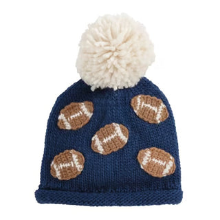 Blue knit hat with brown football patterns and a white pom-pom on a white background