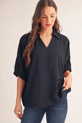Woman wearing a black blouse and blue jeans on a plain background