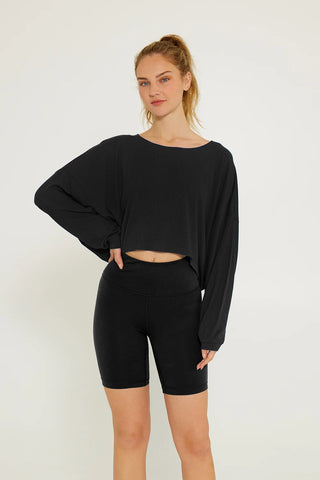 a woman in a cream yoga black ribbed crop top