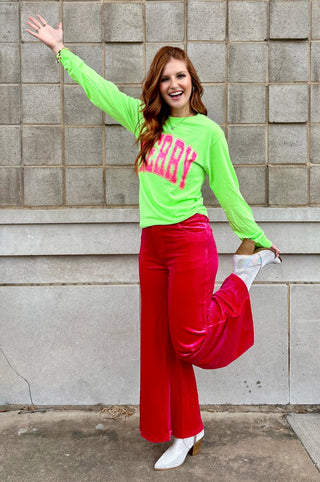 Girl standing in front of wall holding one foot. 