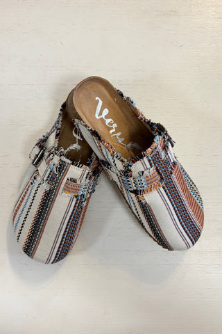 Pair of patterned slippers with 'Very G' branding on a light wooden floor.