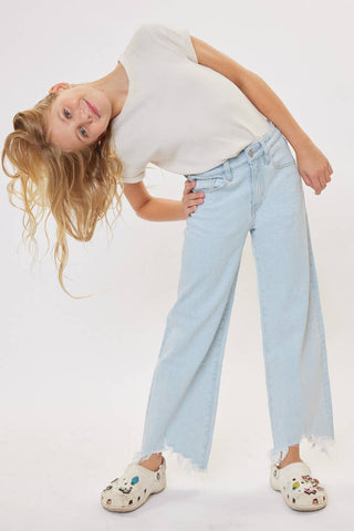Person wearing a white t-shirt, light blue jeans, and colorful shoes on a plain background