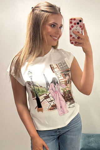 Woman wearing a white t-shirt with a graphic design, taking a selfie.