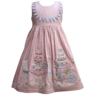 Pink dress with cake design and ruffled collar on a white background