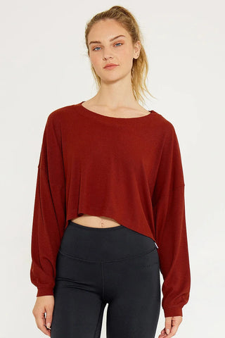 A women in a wine colored ribbed crop top