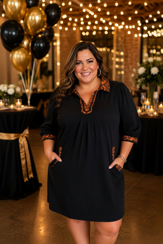 A  woman wearing a black umgee dress with eopard trim
