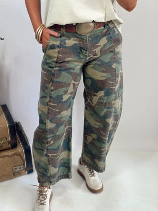Person wearing camouflage pants with a plain background