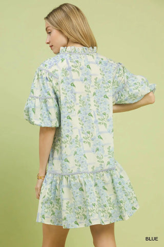 Woman wearing a floral dress with puff sleeves on a light green background
