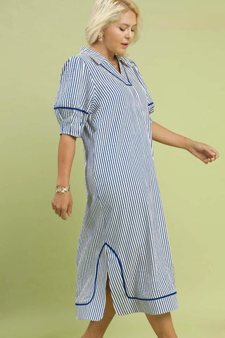Woman wearing a blue and white striped dress on a green background