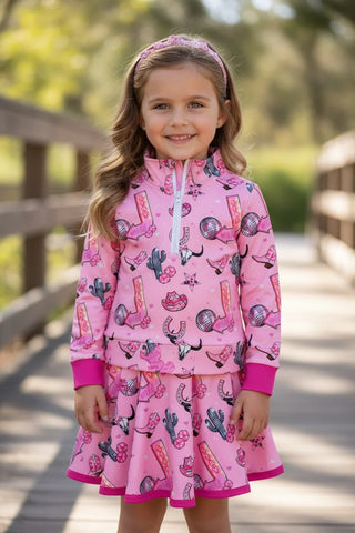 Young girl wearing a pink outfit with horse print on a wooden bridge