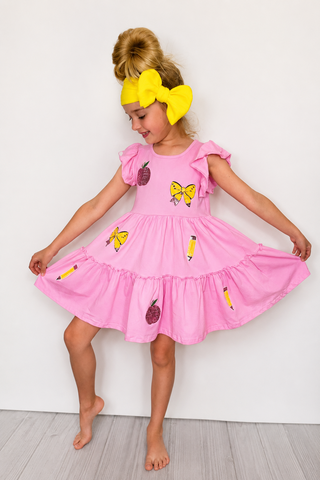 Little girl wearing back to school dress.