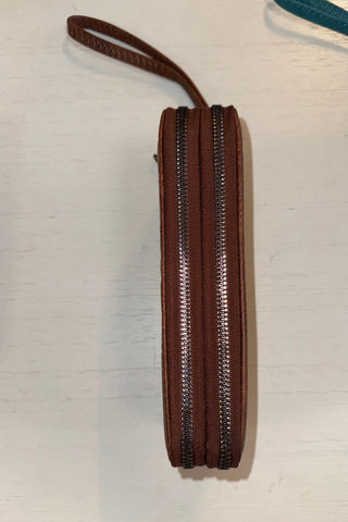 Brown zippered pouch on a light wooden surface