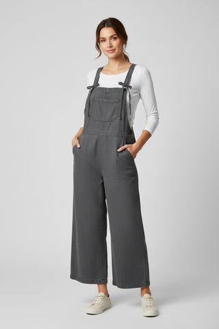 Woman wearing gray overalls on a white background