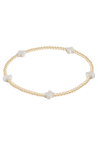 Gold bracelet with white beads on a white background
