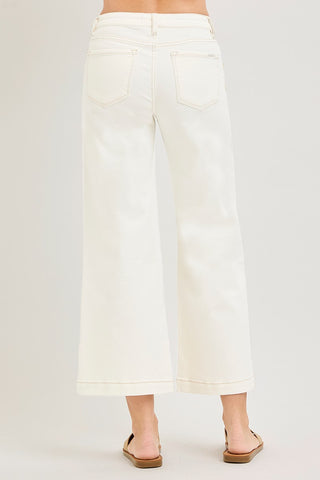 White pants worn by a person on a plain background