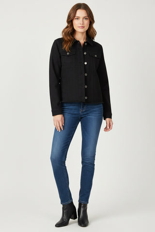 Woman wearing a black jacket, blue jeans, and black boots on a white background
