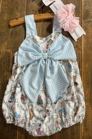 Baby romper with bow and headband on a wooden background
