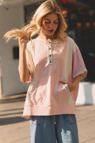Woman wearing a pink top with lace details outdoors