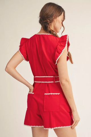 Woman wearing a red dress with white trim on a beige background