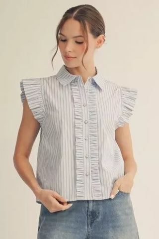 Woman wearing a light blue striped shirt with ruffled sleeves on a beige background