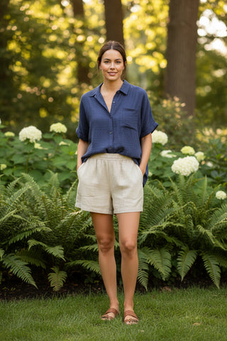Woman standing in a garden with greenery and flowers around her