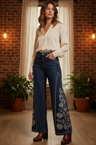 a pair of dark blue wide leg jeans with floral stitching