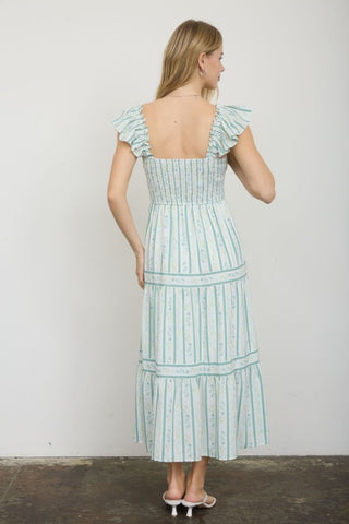 Woman wearing a light blue striped dress against a plain background