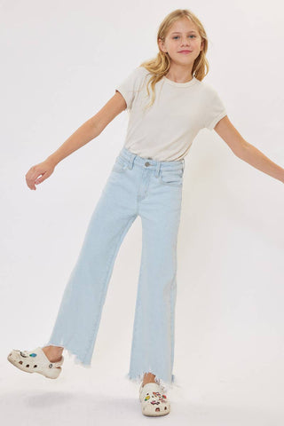 Young girl wearing a white t-shirt and light blue jeans on a white background