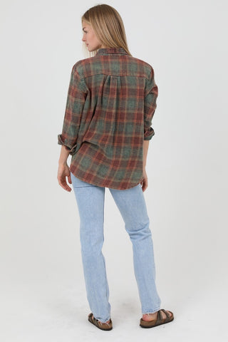 Woman wearing a plaid shirt and light blue jeans on a white background