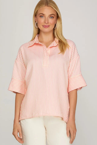 Woman wearing a pink and white striped shirt against a plain background