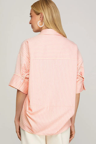 Woman wearing a pink and white striped shirt against a plain background