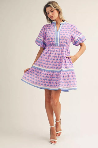 Woman wearing a pink and blue patterned dress on a white background