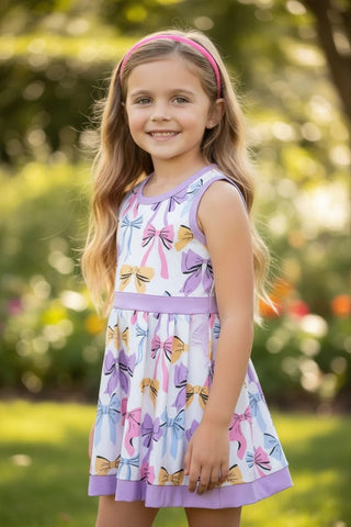 Young girl wearing a colorful dress with bow pattern outdoors