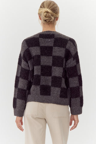 Person wearing a checkered sweater with a white background