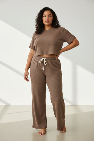 Woman wearing a brown outfit with a white background