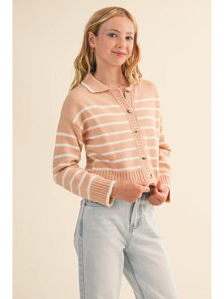 A young woman wearing a light peach and white striped knit cardigan with a collar and button-front closure, paired with light-wash jeans, against a plain beige studio background.