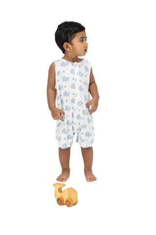 Child wearing a white sleeveless romper with blue patterns on a white background
