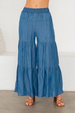 Blue tiered pants worn by a person on a white background