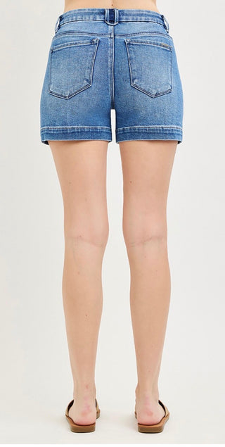 Denim shorts worn by a person on a white background