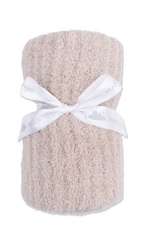 A rolled beige terry cloth baby blanket or towel tied with a white ribbon bow, shown on a plain white background.