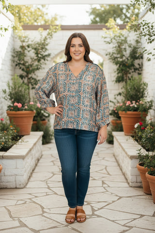 A women standing in a stone walk way in a colorful top 