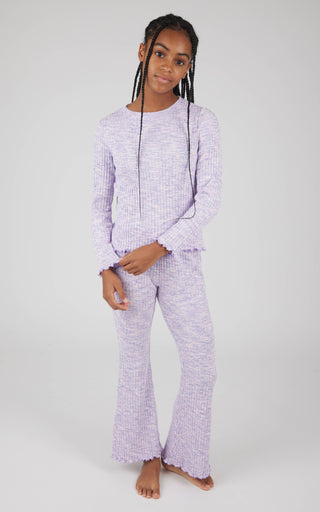Person wearing a purple checkered pajama set on a white background