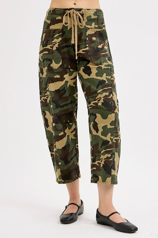 Camouflage pants worn by a person on a white background