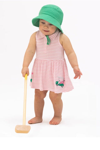 Child wearing a pink dress with a green hat and holding a wooden spoon on a white background