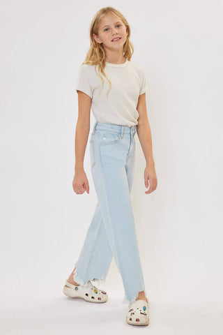 Young girl wearing a white t-shirt and light blue jeans on a white background