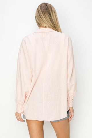 Light pink oversized shirt worn by a person on a white background