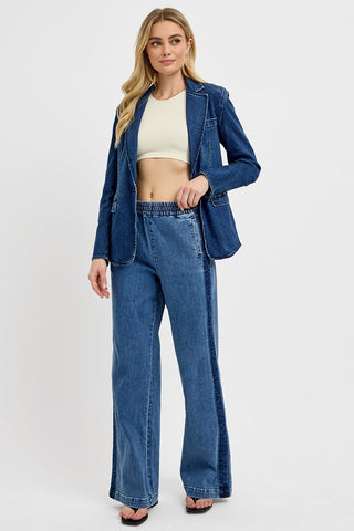 Woman wearing a blue denim jacket and jeans on a white background