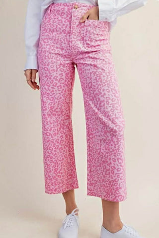 Person wearing pink leopard print pants on a beige background