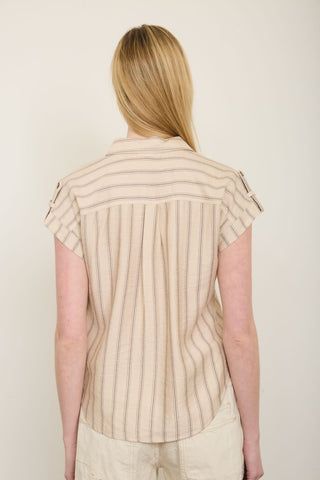 Person wearing a beige striped shirt against a plain background